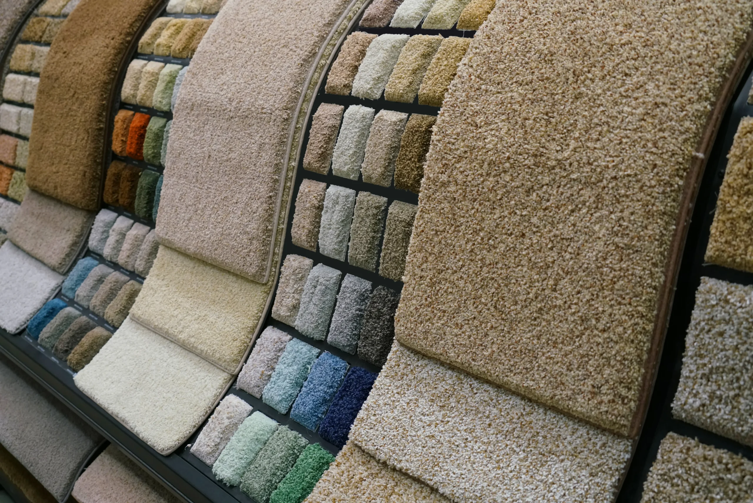 Display rack with carpet samples in various colors and textures at a flooring showroom.